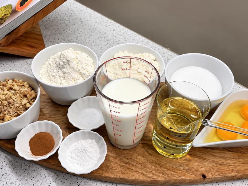 Përbërësit për tatli me arra dhe sherbet: miell, arra, vezë, sheqer, qumësht, vaj vegjetal dhe kanellë.