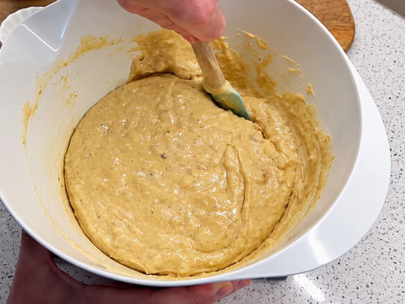 Përzierja e brumit të tatliut me arra me spatulë, derisa përbërësit të bashkohen mirë.